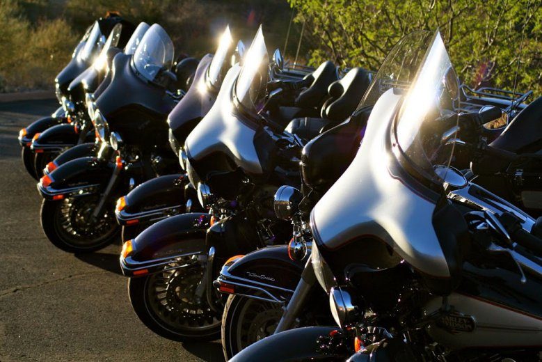 A row of touring motorcycles parked in the sun